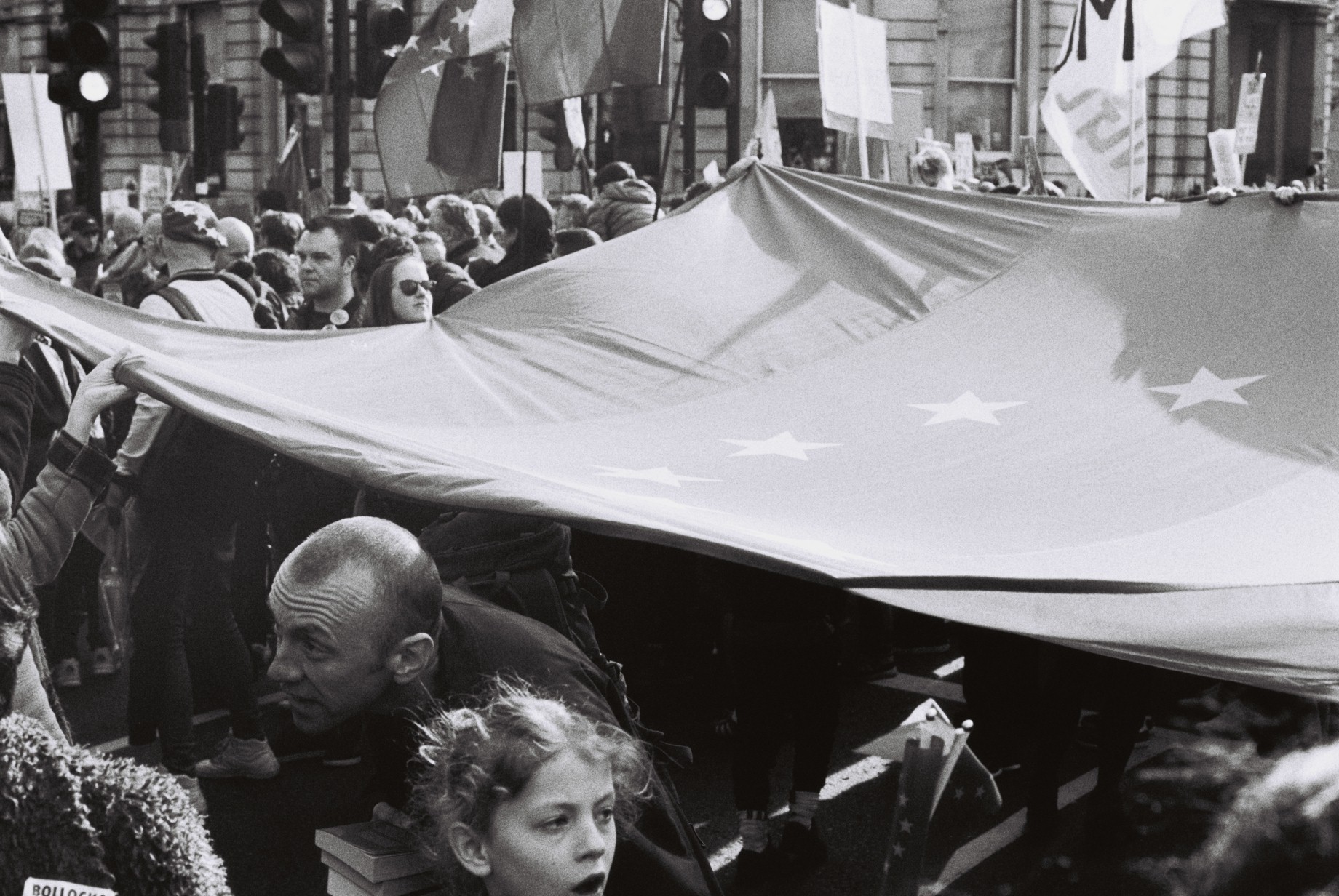 Man coming out from under a giant EU flag