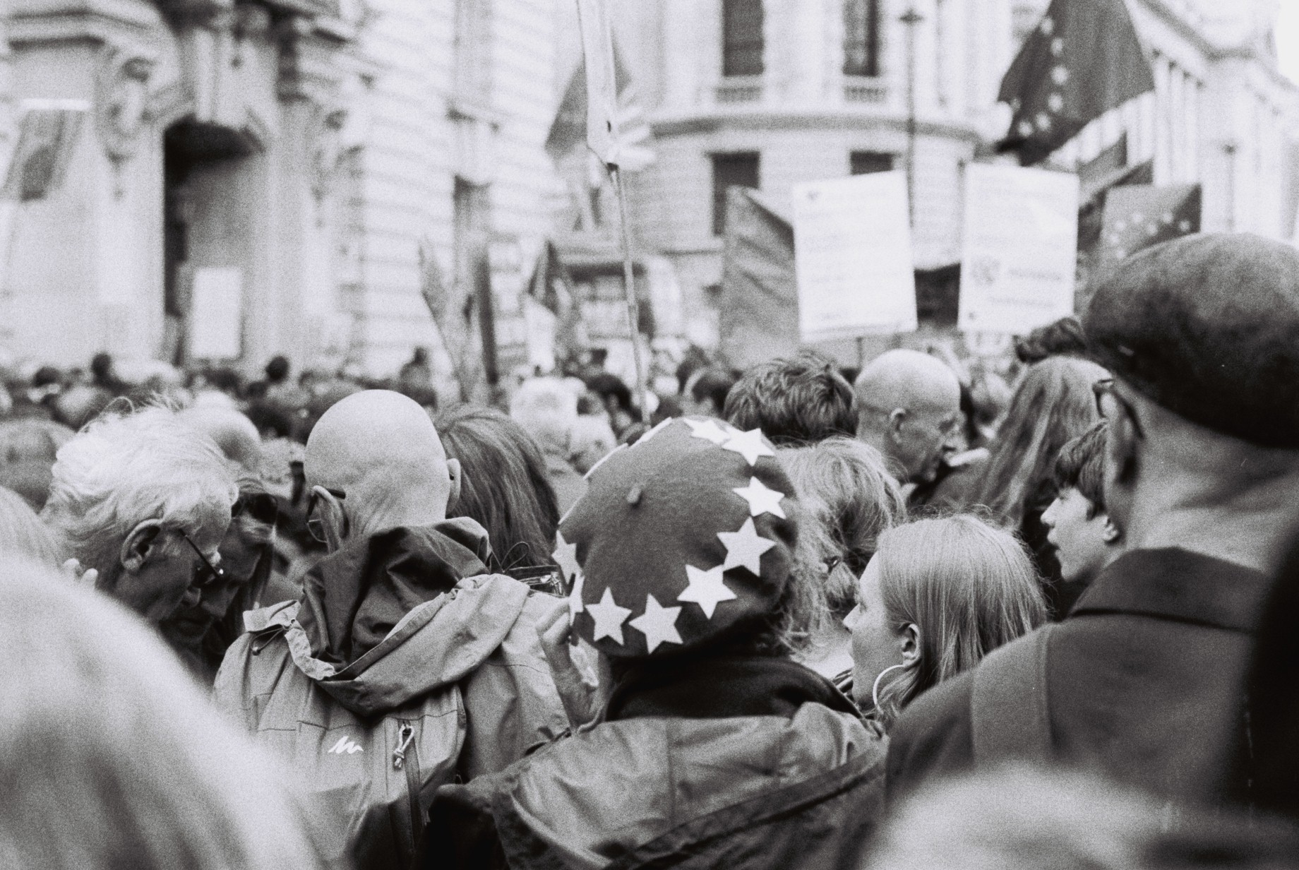 Crowd from the back with a person wearing a starred beret in the middle