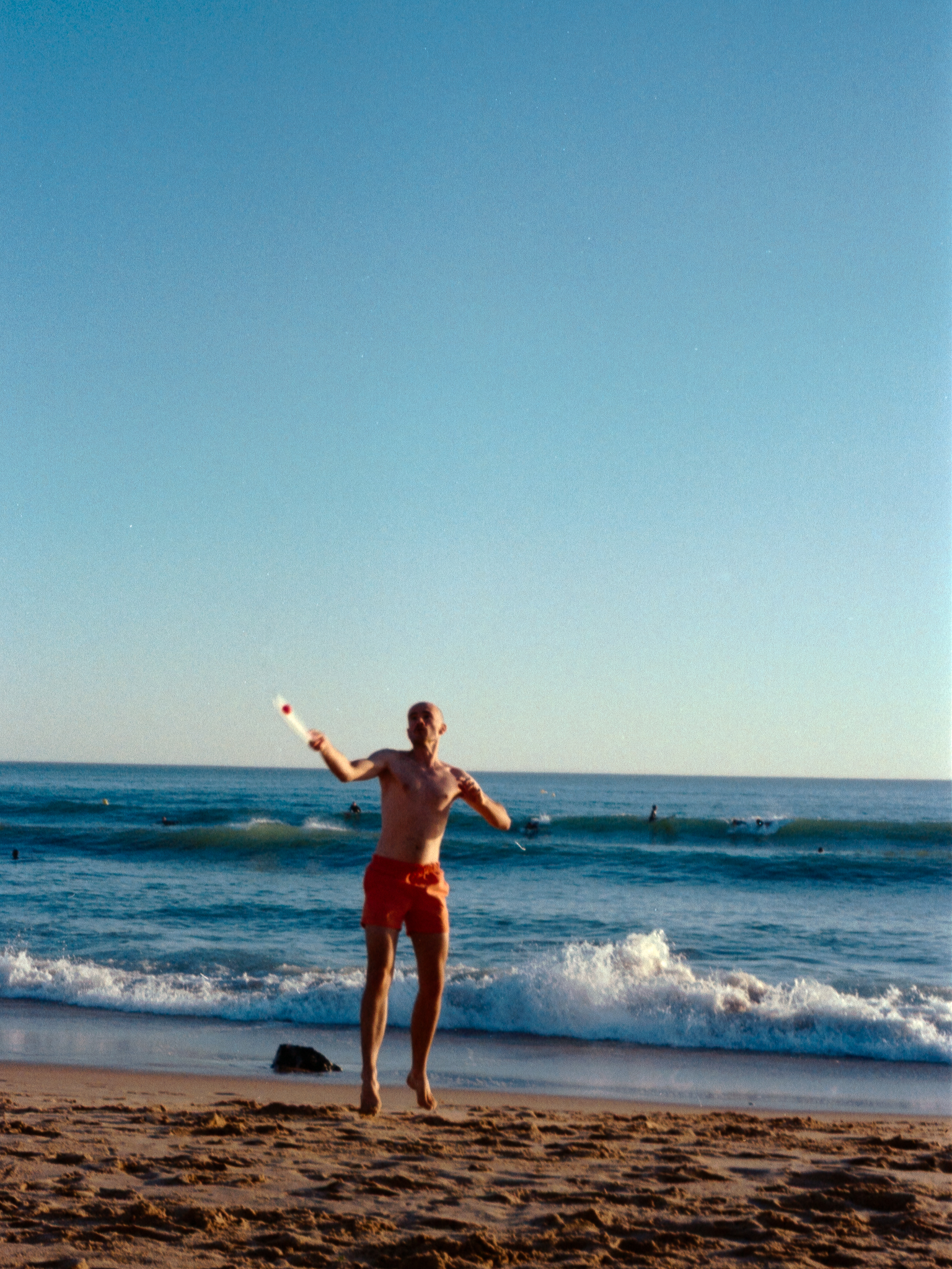 Man playing rackets by the sea